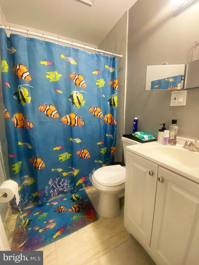 bathroom with vanity, curtained shower, toilet, and tile patterned flooring