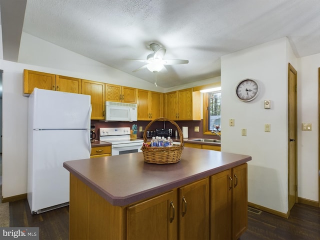 kitchen with white appliances, a center island, vaulted ceiling, and sink