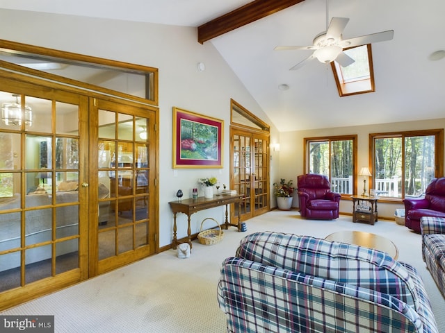 carpeted living room featuring ceiling fan, french doors, and vaulted ceiling with skylight