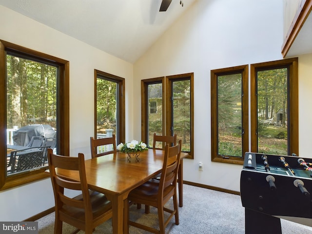 dining area with ceiling fan, light colored carpet, and lofted ceiling