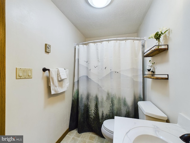 bathroom with sink, toilet, a textured ceiling, and walk in shower