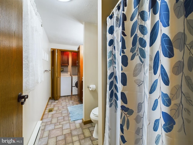 bathroom featuring toilet, a shower with shower curtain, a baseboard radiator, and independent washer and dryer