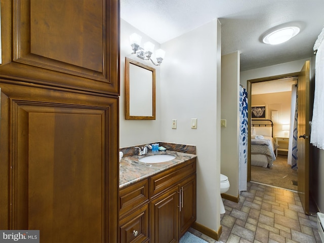 bathroom featuring baseboard heating, vanity, a textured ceiling, and toilet