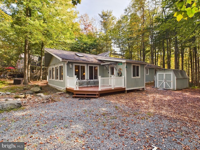 view of front of property featuring a deck and a storage shed