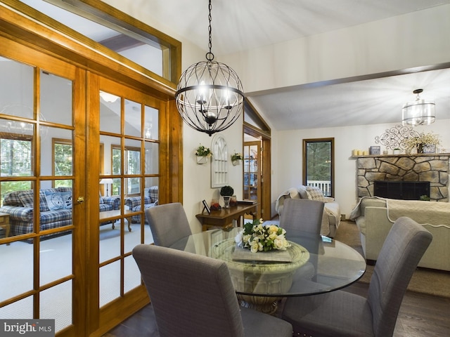 dining room featuring a fireplace, french doors, vaulted ceiling, and dark wood-type flooring