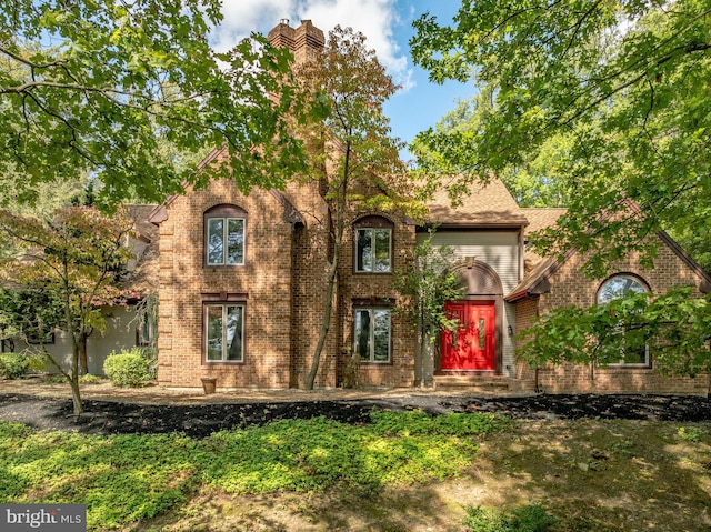 tudor house featuring brick siding