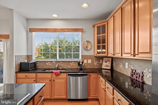 kitchen with light hardwood / wood-style flooring, backsplash, dark stone countertops, sink, and appliances with stainless steel finishes