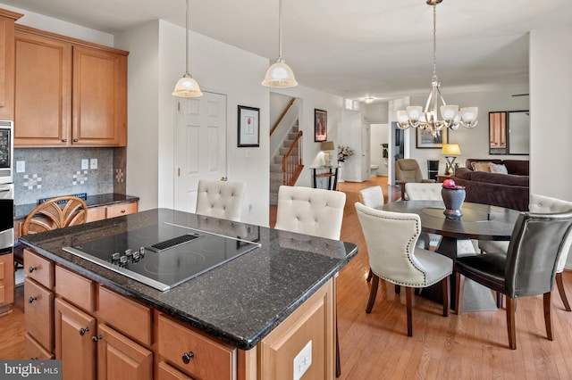 kitchen featuring backsplash, appliances with stainless steel finishes, a center island, and light wood-type flooring