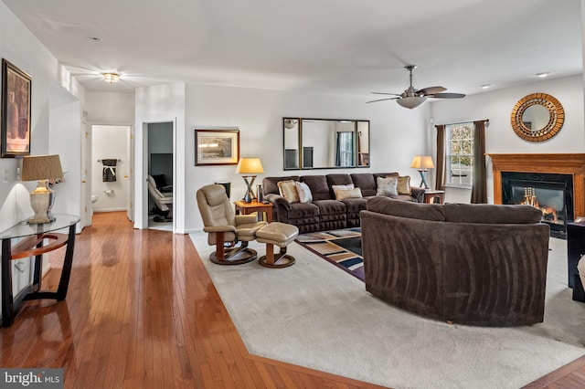 living room featuring wood-type flooring and ceiling fan