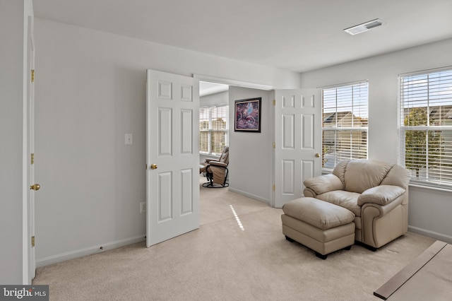 living area featuring light carpet