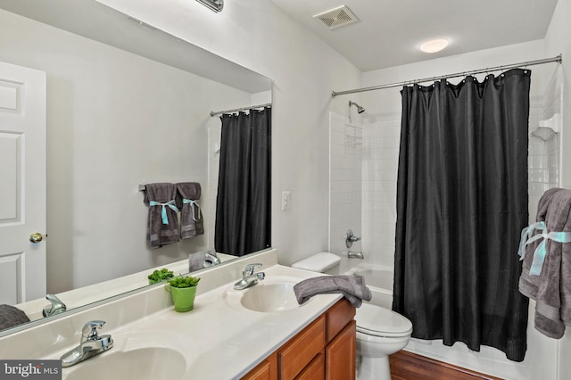 full bathroom with toilet, hardwood / wood-style floors, vanity, and shower / tub combo