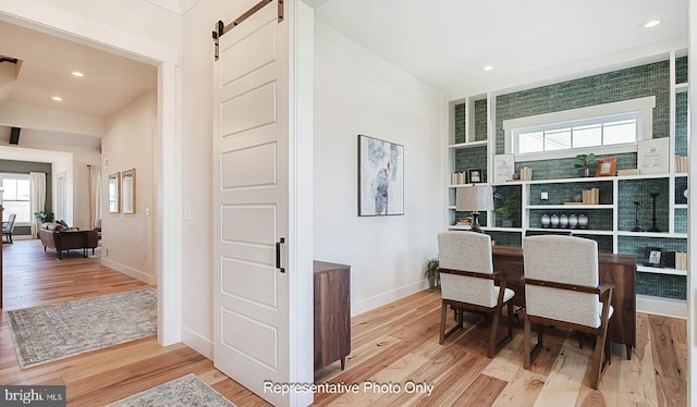 dining space featuring a barn door and light hardwood / wood-style floors