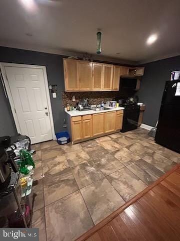 kitchen featuring light hardwood / wood-style flooring, backsplash, and black appliances