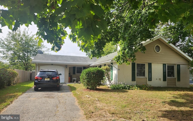 ranch-style house featuring a garage and a front lawn