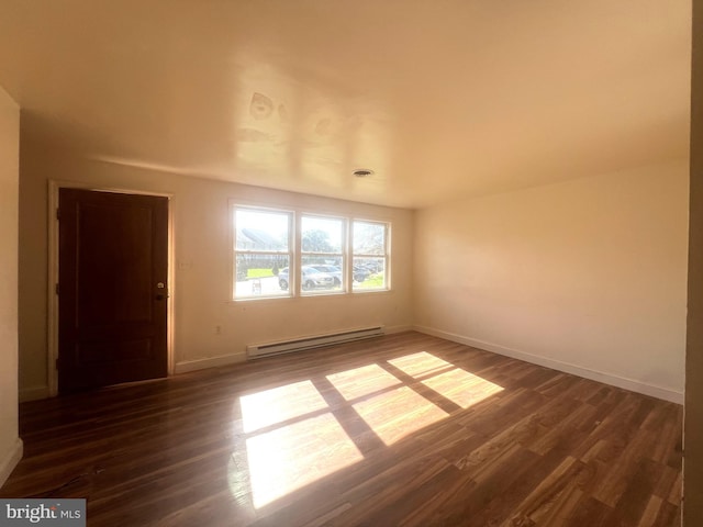 spare room with a baseboard radiator and dark hardwood / wood-style flooring