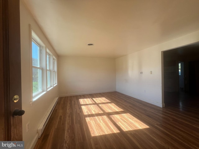 empty room with a baseboard radiator and dark hardwood / wood-style floors