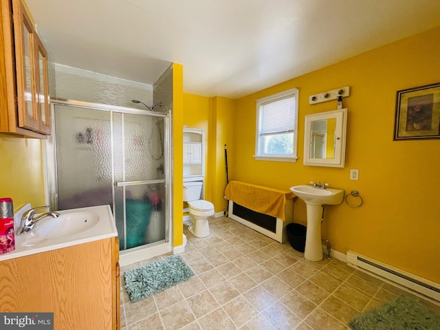 bathroom with a shower with door, toilet, a baseboard heating unit, and sink