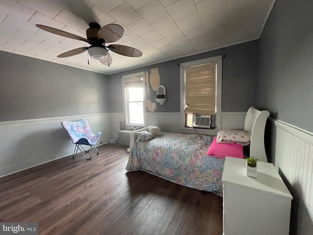 bedroom featuring radiator heating unit, cooling unit, ceiling fan, and dark wood-type flooring