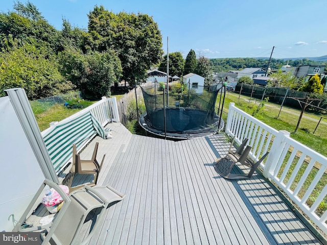 deck with a trampoline and a yard