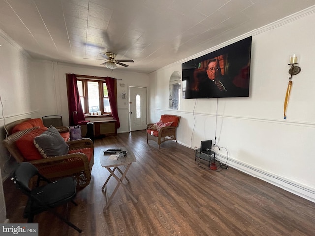 living room with ceiling fan, ornamental molding, and dark wood-type flooring