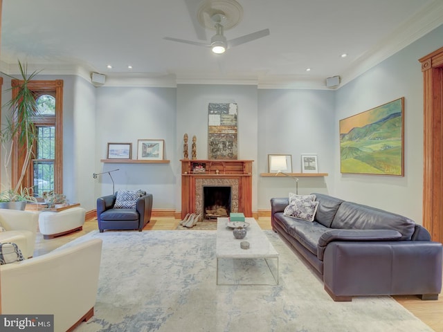 living room featuring crown molding, light hardwood / wood-style floors, and ceiling fan