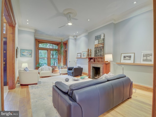 living room featuring ceiling fan, ornamental molding, and light hardwood / wood-style floors