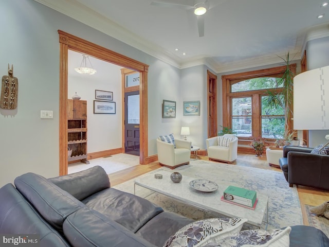 living room with light hardwood / wood-style floors, ornamental molding, and ceiling fan