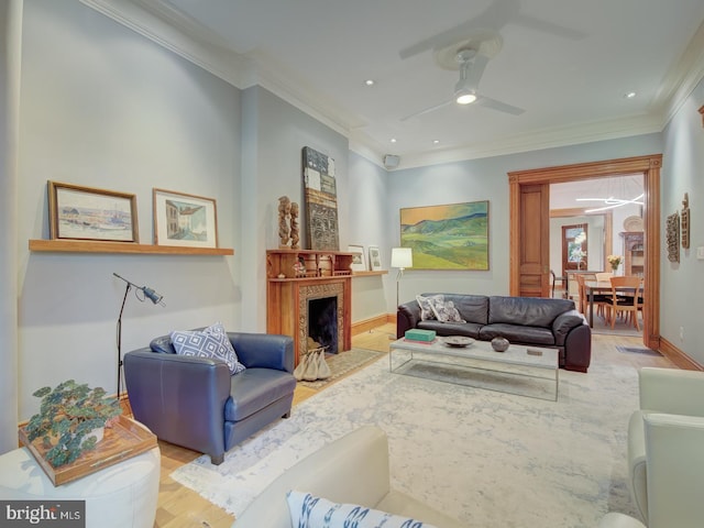 living room featuring light hardwood / wood-style flooring, ceiling fan, and crown molding