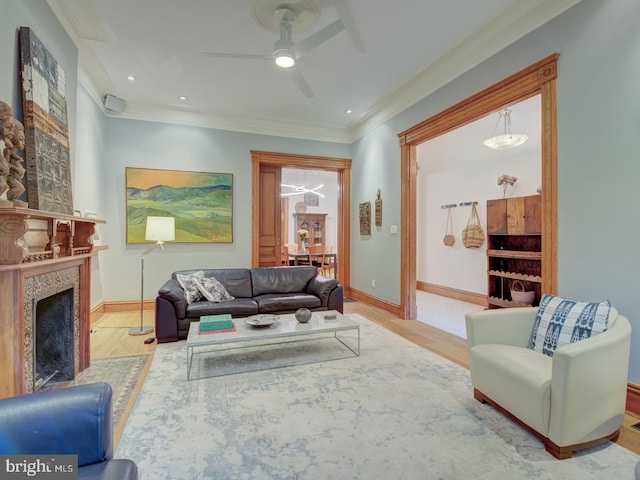 living room with light wood-type flooring, ceiling fan, and crown molding