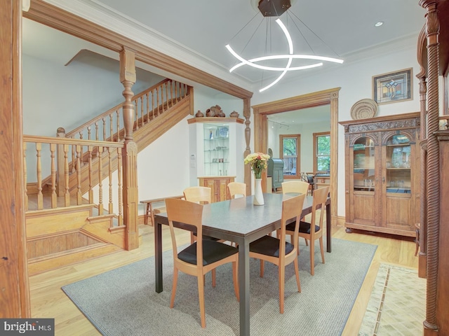 dining space with an inviting chandelier, hardwood / wood-style flooring, and crown molding