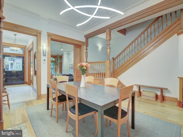 dining room with crown molding, light hardwood / wood-style floors, and a notable chandelier