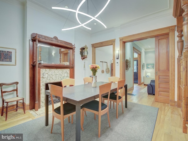 dining room with light wood-type flooring, crown molding, and a chandelier