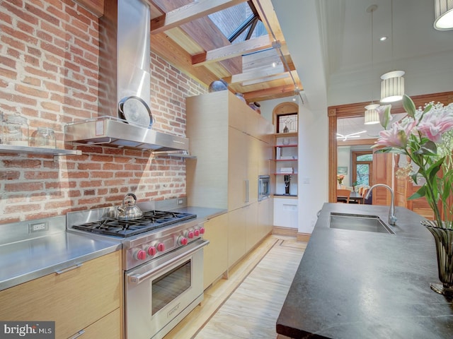 kitchen with beamed ceiling, sink, wall chimney exhaust hood, luxury stove, and stainless steel counters