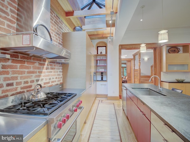 kitchen with sink, beam ceiling, wall chimney exhaust hood, stainless steel appliances, and light hardwood / wood-style flooring