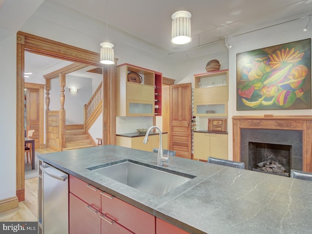 kitchen featuring sink, stainless steel dishwasher, a premium fireplace, crown molding, and light hardwood / wood-style floors