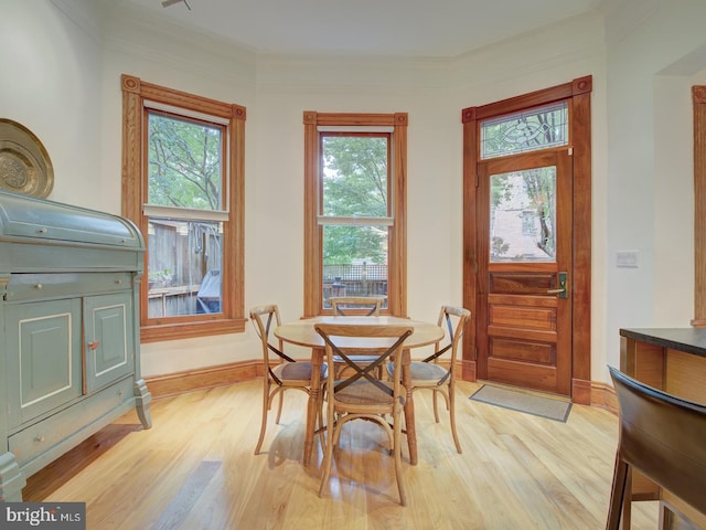 dining room featuring light hardwood / wood-style flooring and crown molding