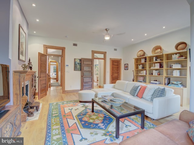 living room with light hardwood / wood-style flooring and ceiling fan