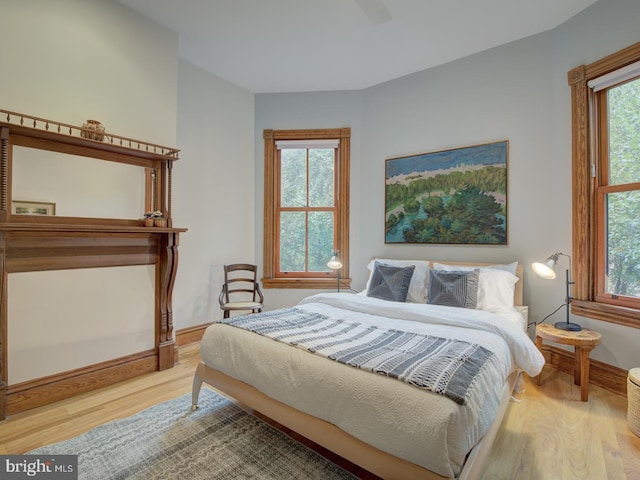 bedroom with multiple windows, ceiling fan, and light hardwood / wood-style flooring