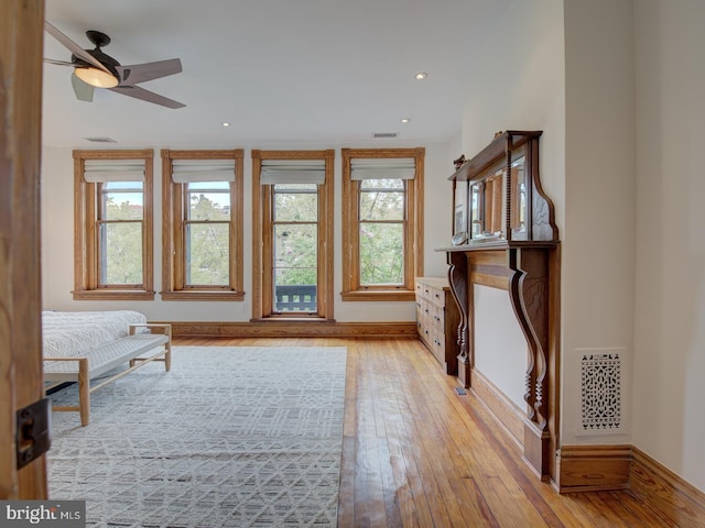 unfurnished bedroom with multiple windows, light wood-type flooring, and ceiling fan