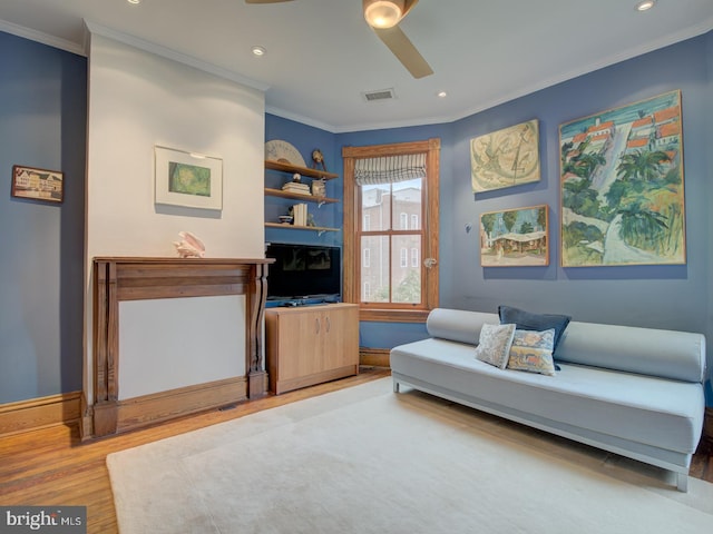 living room with wood-type flooring, crown molding, and ceiling fan