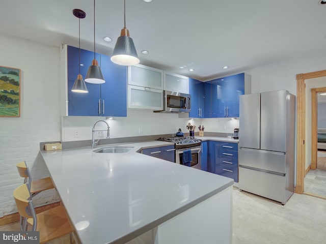 kitchen with sink, kitchen peninsula, hanging light fixtures, stainless steel appliances, and blue cabinets