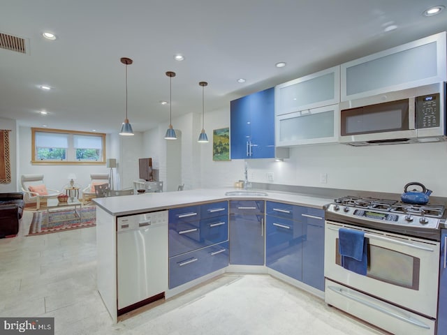 kitchen featuring blue cabinets, kitchen peninsula, sink, white appliances, and decorative light fixtures