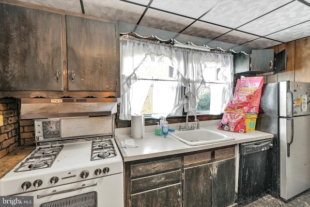 kitchen featuring black dishwasher, sink, stove, stainless steel refrigerator, and dark brown cabinetry