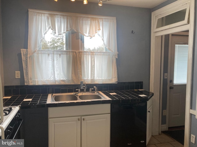 kitchen featuring a wealth of natural light, white cabinetry, and tile countertops