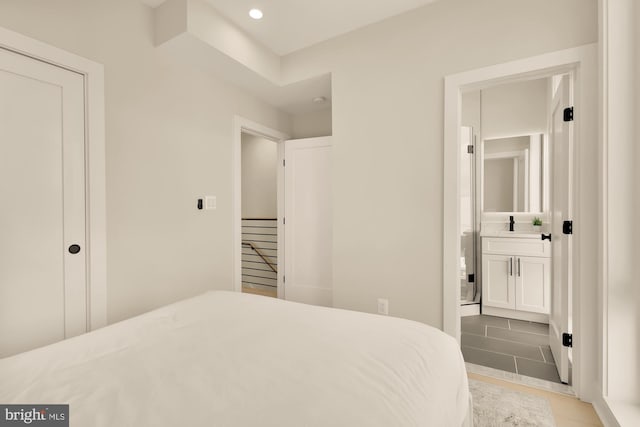 bedroom featuring light tile patterned flooring and ensuite bath