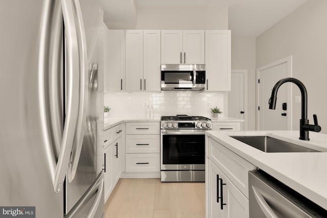 kitchen featuring light hardwood / wood-style floors, stainless steel appliances, and white cabinets