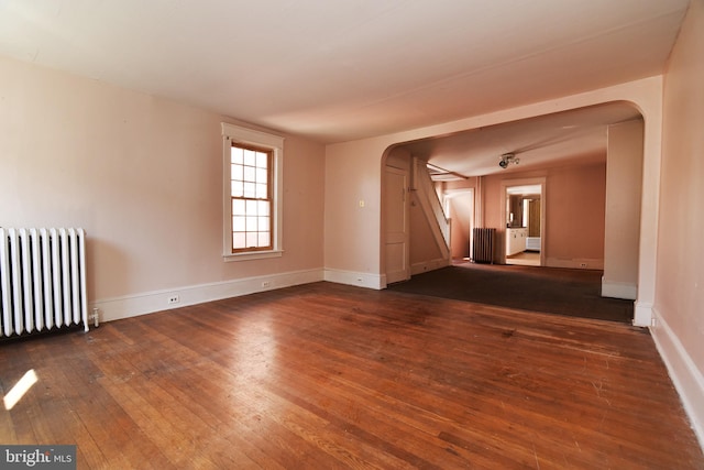 spare room featuring radiator and dark hardwood / wood-style flooring