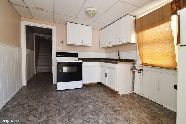 kitchen featuring white cabinetry, white range oven, a paneled ceiling, and sink