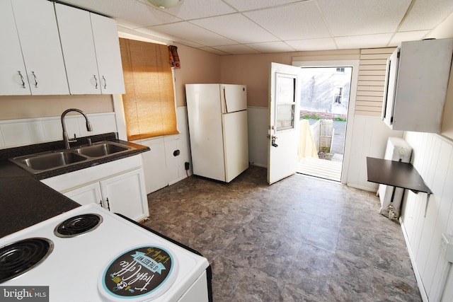 kitchen featuring white appliances, sink, a drop ceiling, and white cabinets