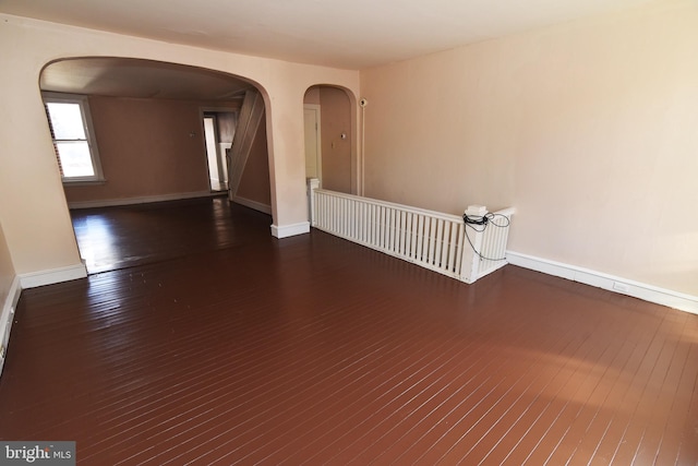 empty room with dark hardwood / wood-style flooring